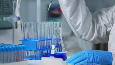 Close-up-of-researcher-testing-liquid-sample-using-micropipette