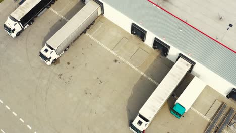 Aerial-view-of-the-logistics-warehouse-with-trucks-waiting-for-loading