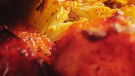 an extreme close up of roasted vegetables including cauliflower, red peppers, and green peppers