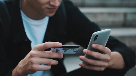 ein junger student zahlt online mit kreditkarte.