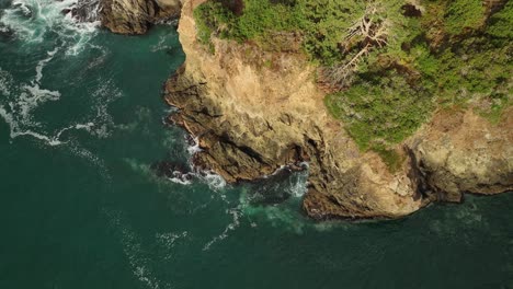 Overhead-aerial-view-of-California's-steep-and-rocky-coastline-on-a-warm-summer-day