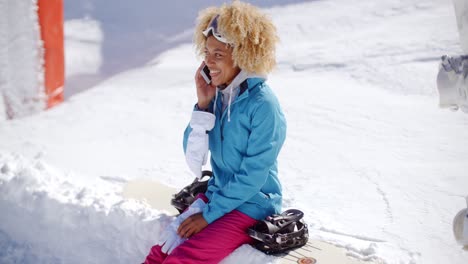 mujer riendo hablando en su móvil en la nieve