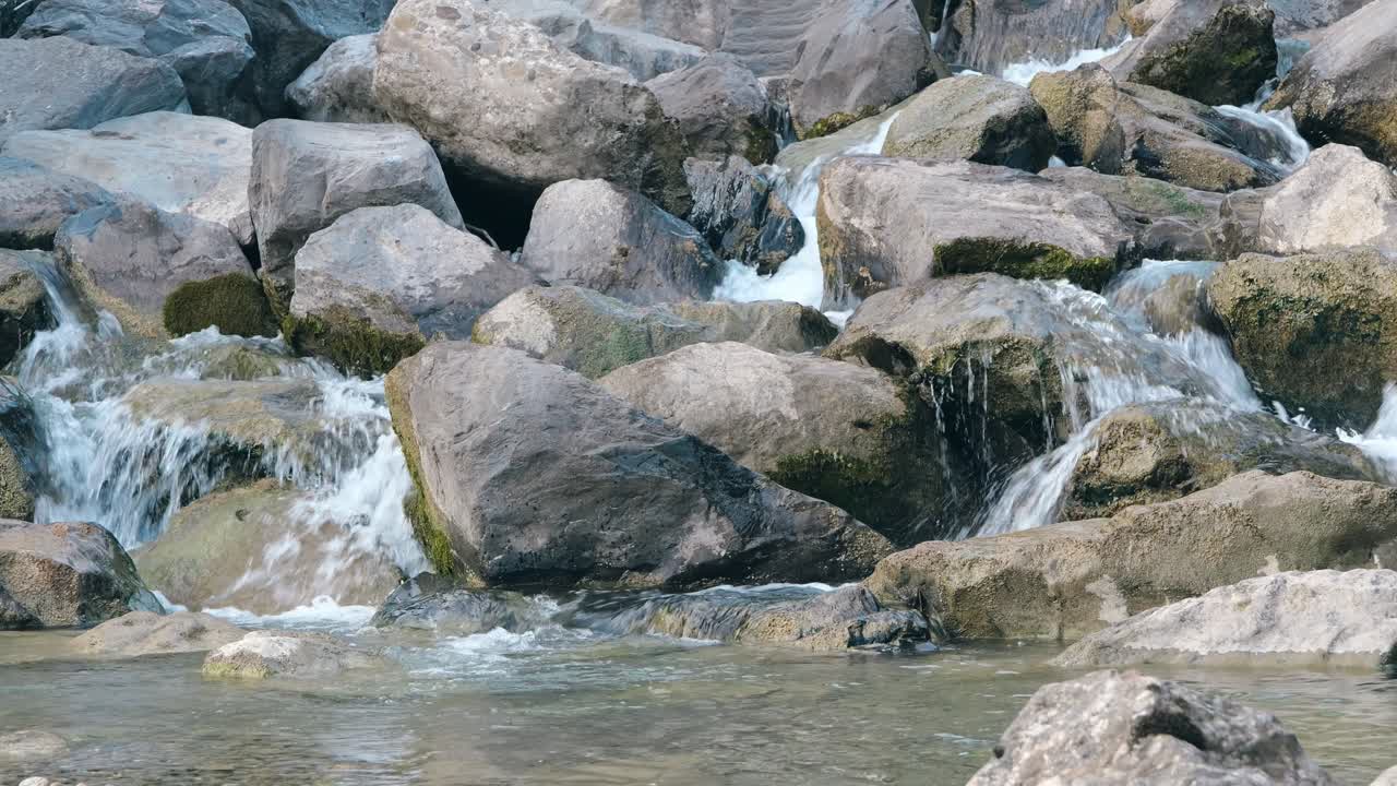 Serene shot of clear stream flowing over large pebbles in Walenstadt, Kanton St. Gallen, Switzerland.
