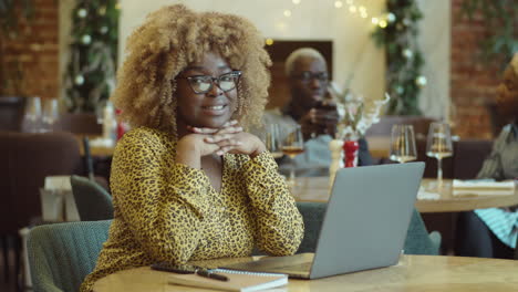 portrait of cheerful african american businesswoman in cafe