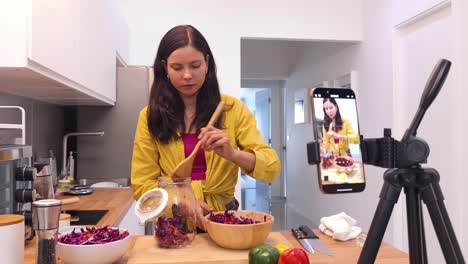 una mujer demuestra cómo hacer ensalada de repollo rojo fermentado