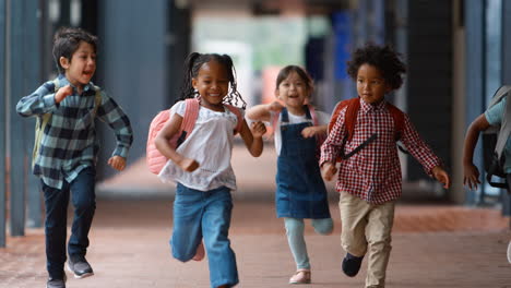 Gruppe-Multikultureller-Grundschüler,-Die-Draußen-In-Der-Schule-Auf-Dem-Gehweg-Laufen