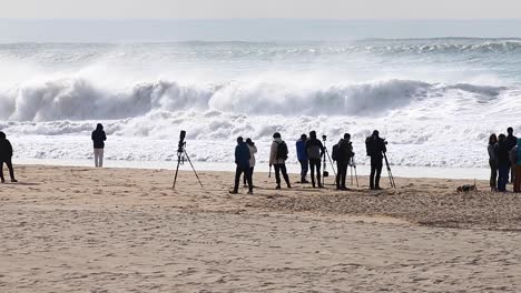 Photographers-and-surfers-waiting-for-the-big-event-in-Carcavelos,-Portugal-with-perfect-waves-and-expert-tube-riders