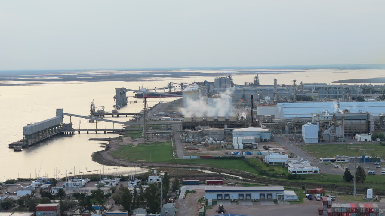 Truck shot of the industrial port area of Bahia Blanca, zoom in the industry buildings, harbor view, copy space