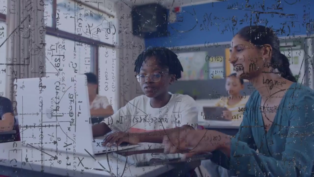 Student typing as teacher coming helping with math formulas overlaying growing over laptop in class