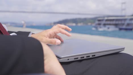 Thoughtful-businessman-opens-his-laptop-and-works.-Slow-motion.