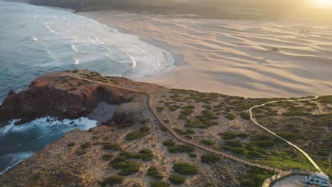 aerial establishing at sunrise from praia da bordeira in the region of algarve, portugal