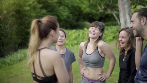 happy sporty people talking in park