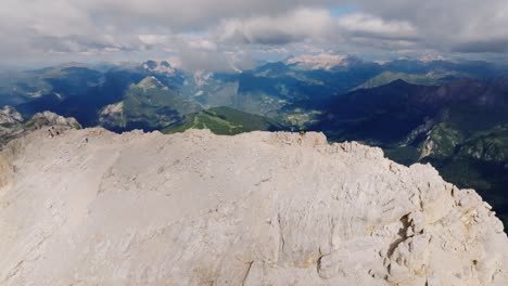 toma de órbita aérea que muestra a un grupo de excursionistas en la cima de la montaña de monte pelmo en italia durante la luz del sol - imágenes espectaculares de drones que muestran el paisaje montañoso y el valle