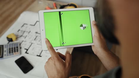 Handheld-Video-Eines-Tischlers,-Der-Etwas-Auf-Einem-Tablet-Betrachtet