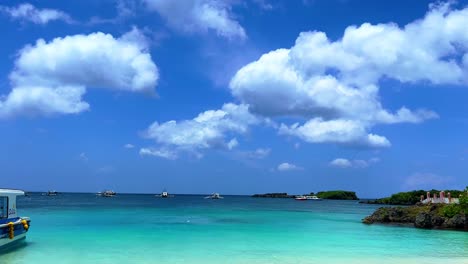 scenic turquoise sea with anchored boats under cloudy sky—ideal for travel, seascapes, and tranquil island lifestyle visuals