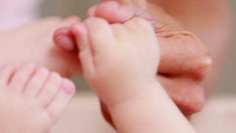 wrinkled hands holding baby hands