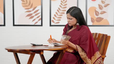 sad indian woman doing household accounts