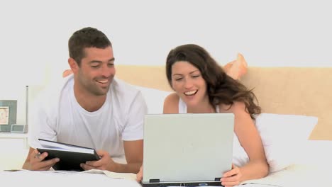 pareja riendo después de ver un video en la computadora portátil