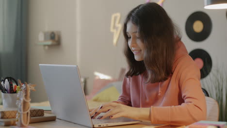 una adolescente estudiando en una computadora portátil