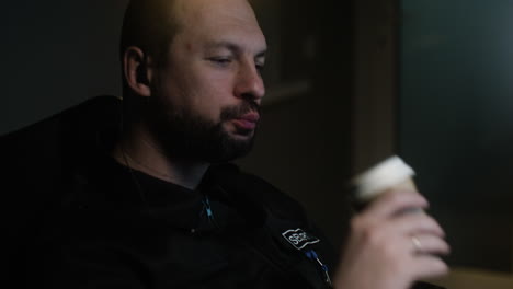 hombre comiendo y bebiendo mientras habla por el walkie talkie.