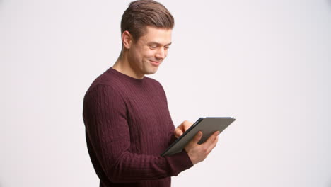 fotografía de un hombre usando una tableta digital contra un fondo blanco