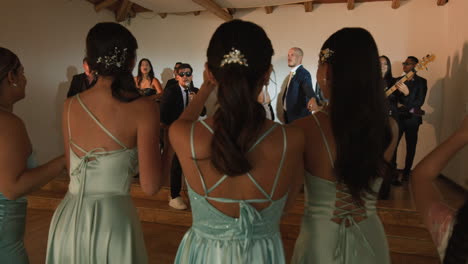 clip of a wedding where the newlyweds dance happily with their guests and bridesmaids.