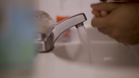 Close-up-static-shot-of-a-young-male-spitting-toothpaste-after-washing-his-teeth