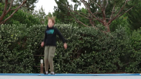 Niño-Divirtiéndose-Saltando-En-Un-Trampolín-Exterior