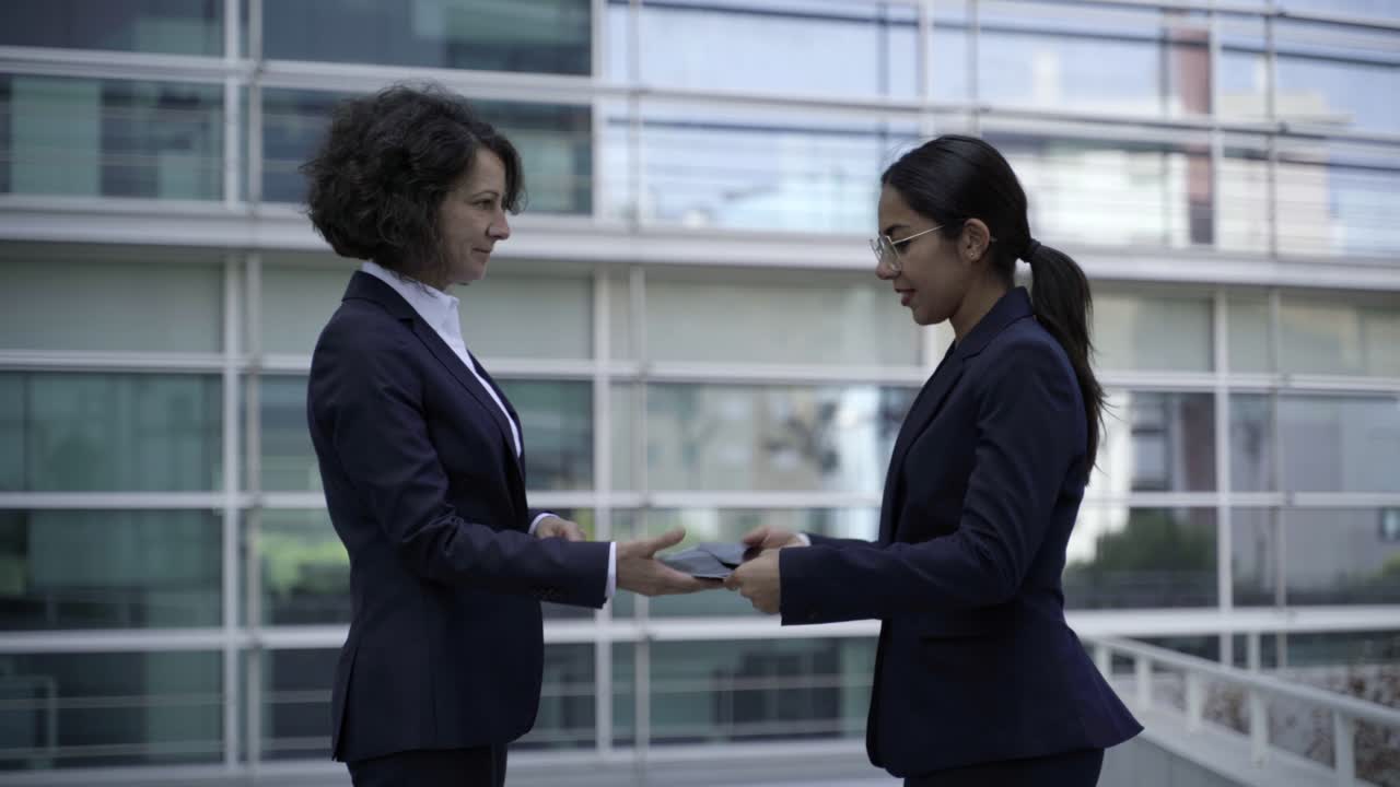 Donne d'affari allegre che parlano all'aperto.