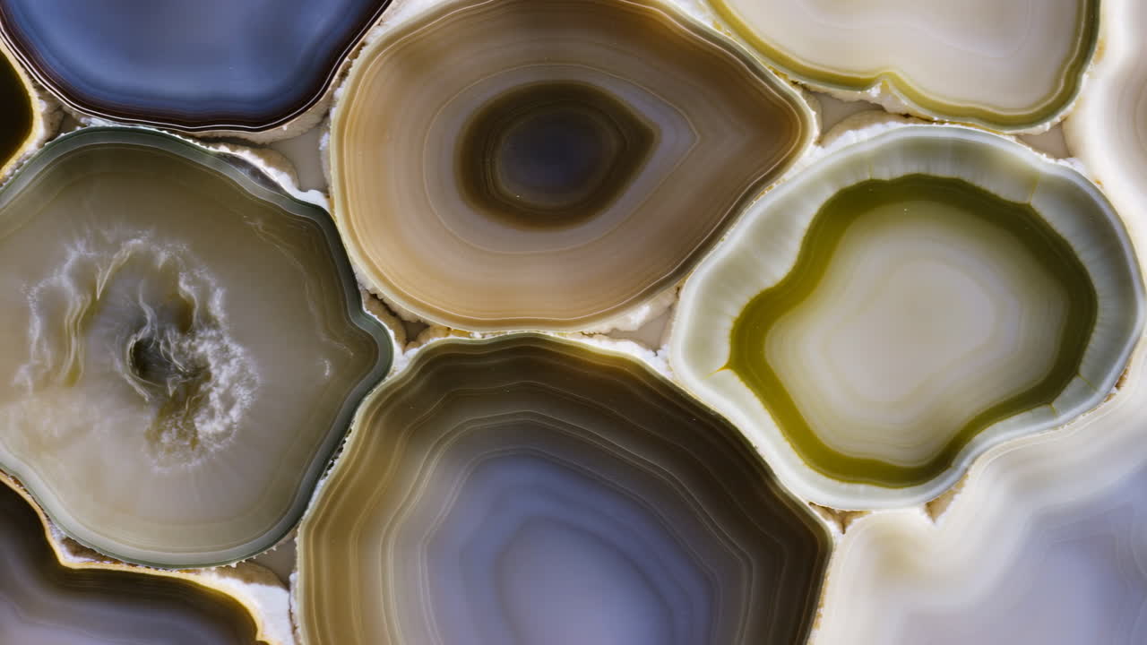 Tranches d'agate macro avec des bandes translucides, coupes transversales de géodes polies rétroéclairées pour révéler des anneaux concentriques