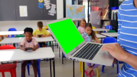 Mid-section-of-Caucasian-female-teacher-using-laptop-in-the-classroom-4k