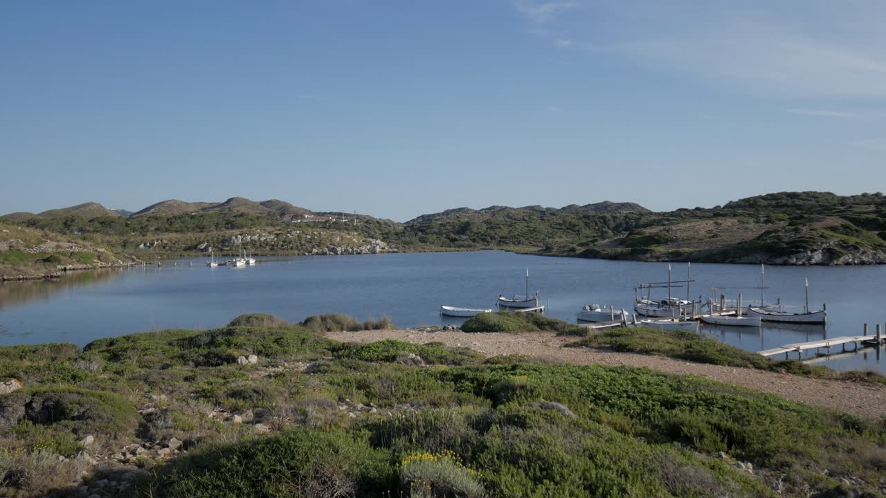 Calm coastal bay with small boats docked at Puerto De Sanitja, Torre De Sanitja