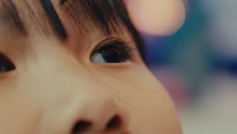 클로즈업: 아시아계 중국인 아이, 아이가 흐릿한 배경으로 잠겼다.