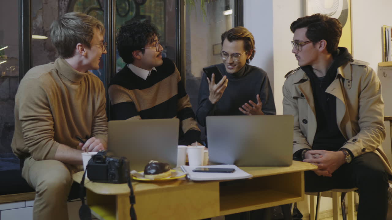 카페에서 전화로 좋은 소식을 읽는 사업가. 집 안에서 친구들과 이야기하는 남자