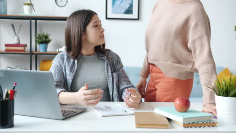 teenage girl doing homework with mother's help