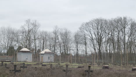 tilt down from grey sky to old overgrown cemetary