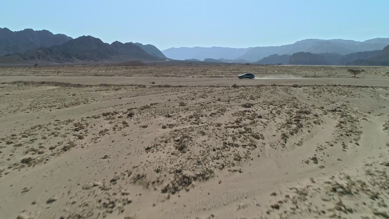 멀리 떨어진 사막 도로 를 따라 운전 하는 빠른 스포츠 자동차 의 공중 광경