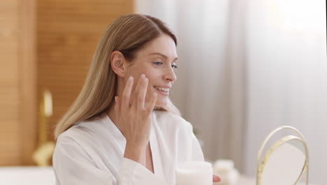 woman applying face cream as part of her skincare routine