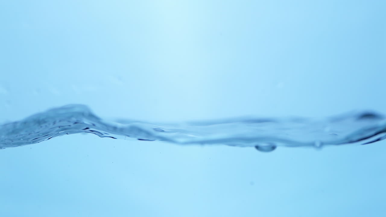 Clean sparkling water creates waves and water bubbles as it moves in a container.