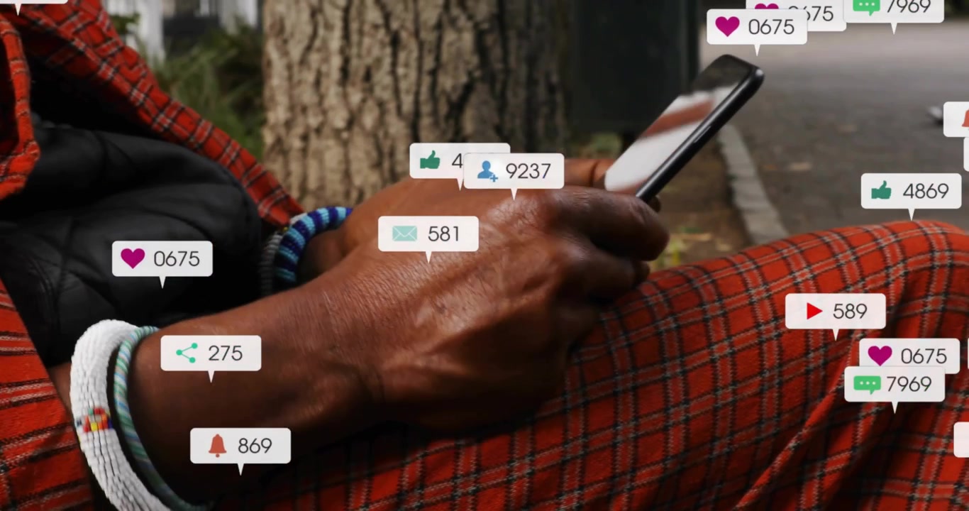 Mature man unfolding smartphone from red plaid wrap tapping screen monitoring social media metrics