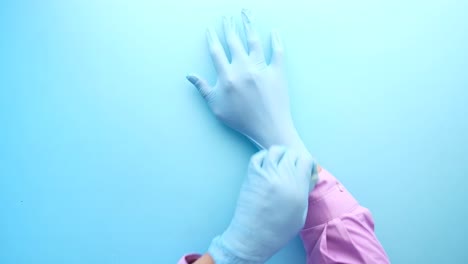 putting on blue medical gloves