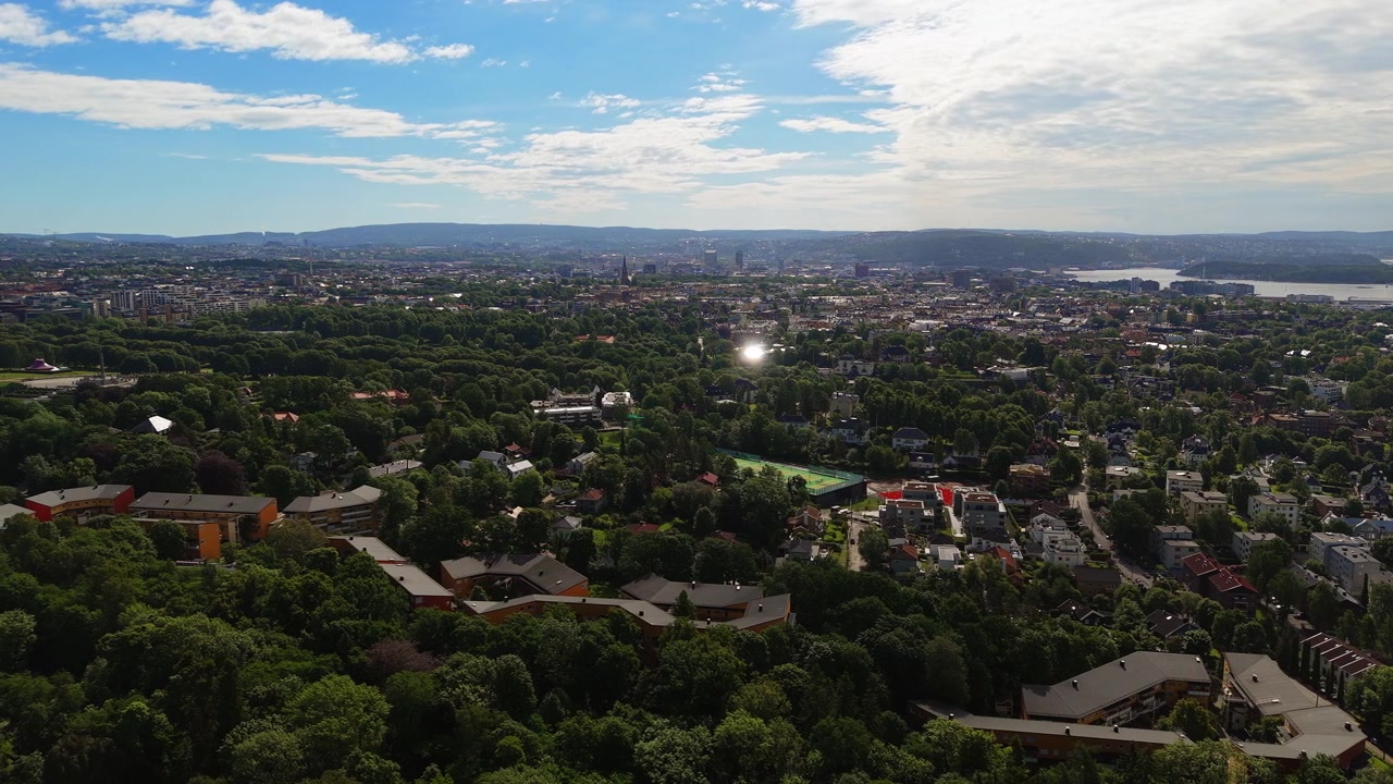 Un'area residenziale verdeggiante con un vasto skyline urbano in lontananza. Perfetto per promozioni immobiliari o servizi di viaggio.