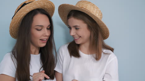 two happy young women looking at a phone