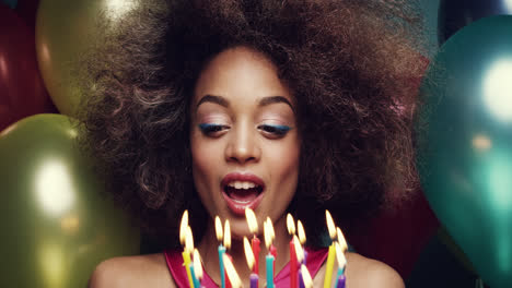 hermosa mujer hispana soplando velas celebrando su cumpleaños fondo de globo multicolor - dragón épico rojo