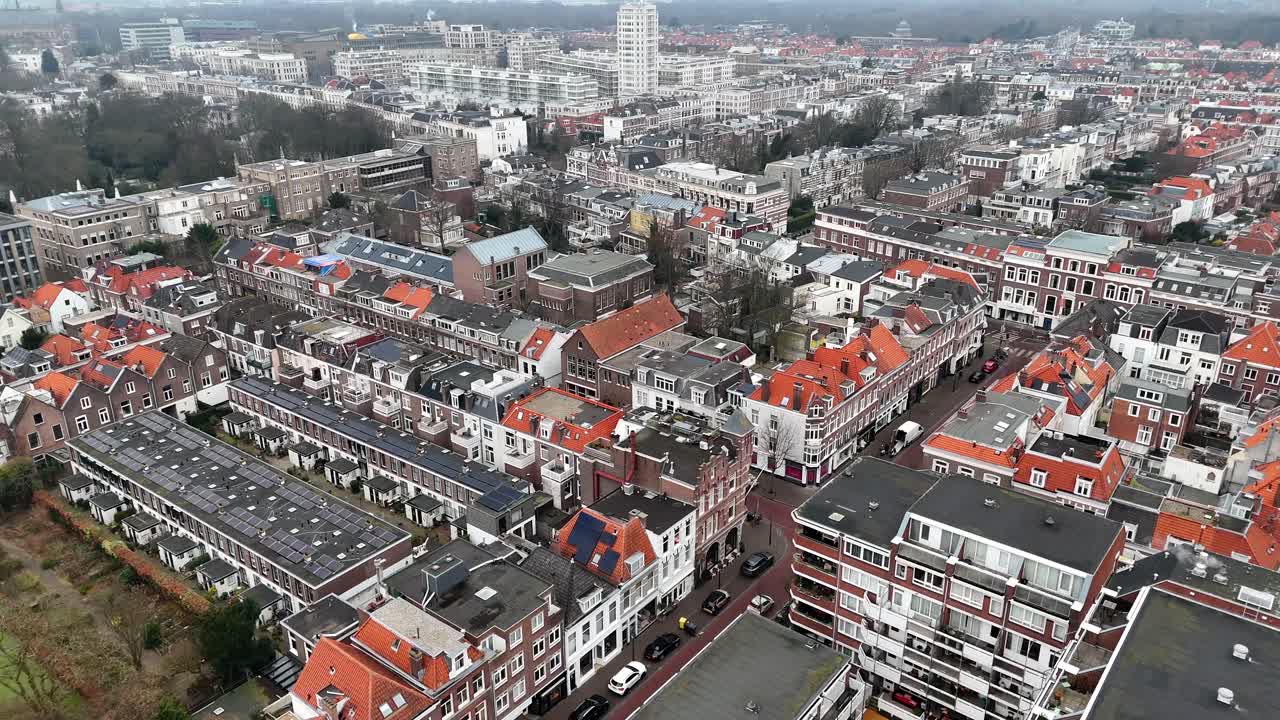 European Urban Living. Aerial view of Den Haag The Hague with housing area and streets. Drone top down flyover. Dark and orange colored roofs of historic buildings and homes. Dutch architecture.
