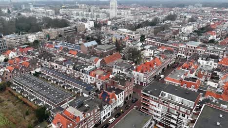 european urban living. aerial view of den haag the hague with housing area and streets. drone top down flyover. dark and orange colored roofs of historic buildings and homes. dutch architecture.