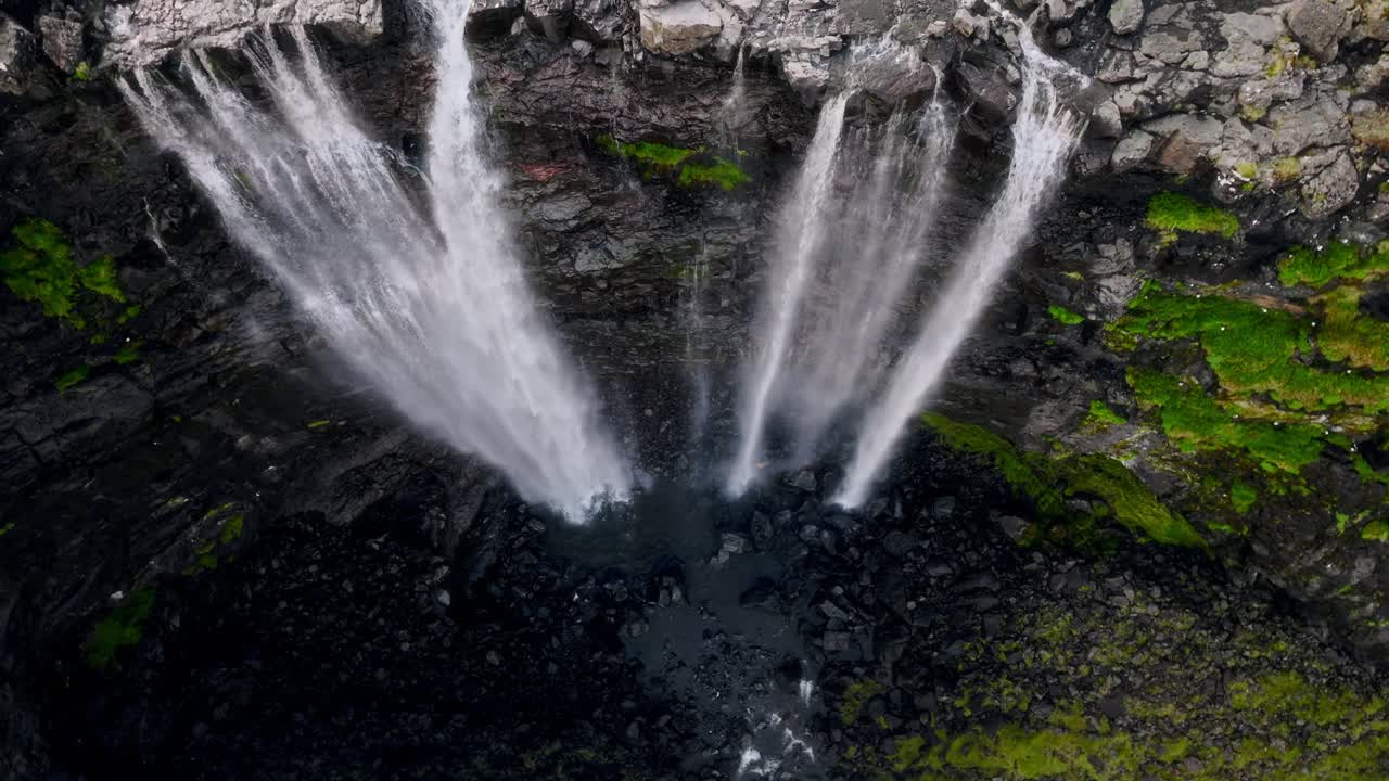impresionantes cascadas que se sumergen en una cuenca rocosa en las islas feroe, vista aérea
