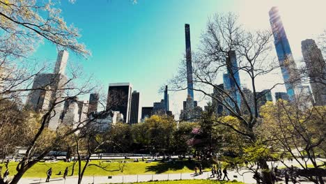 people enjoying themselves in central park in new york city with the manhattan skyline in the background
