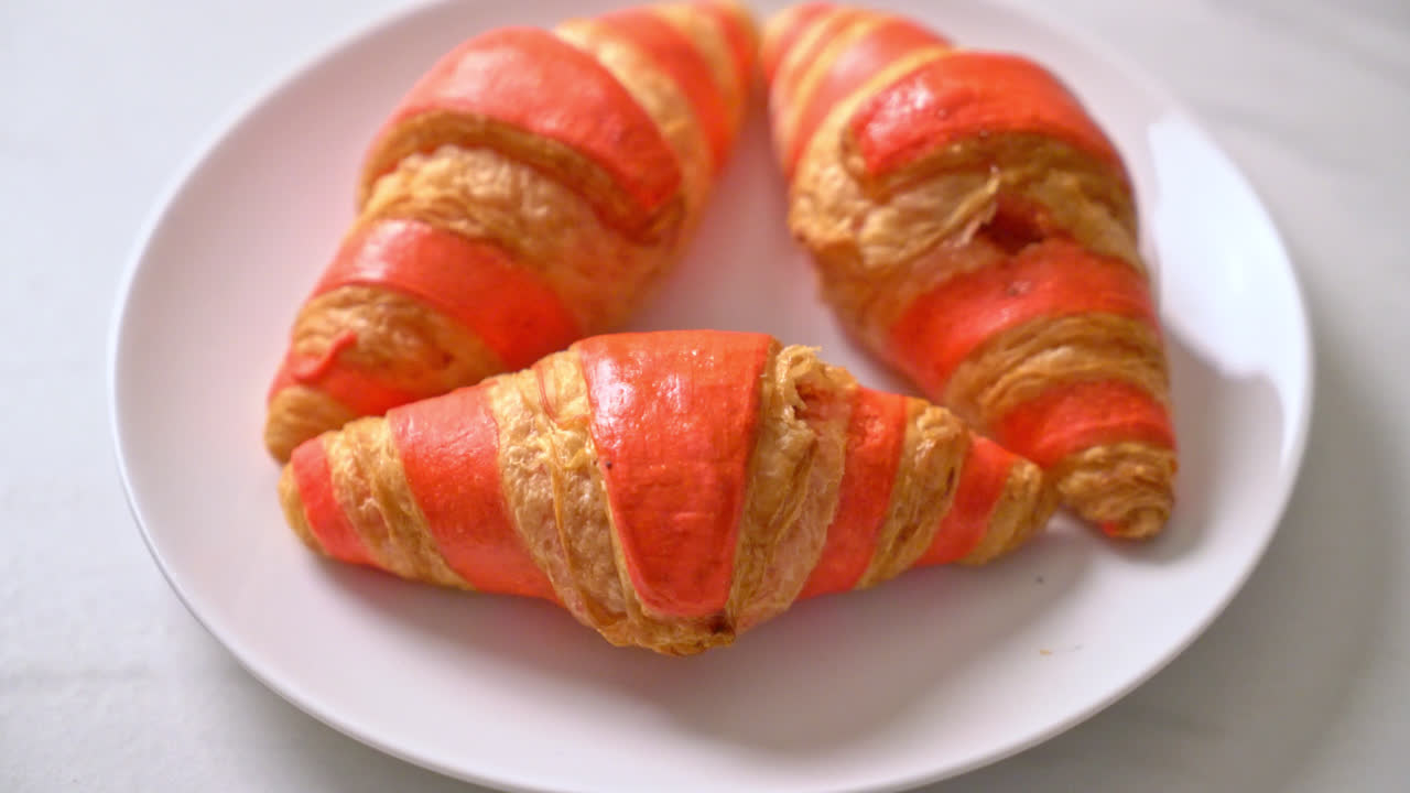 Croissant fresco con salsa de mermelada de fresa en la placa