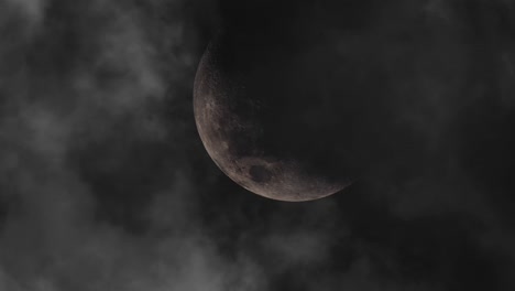 zoom in, moon at night with dark clouds all around